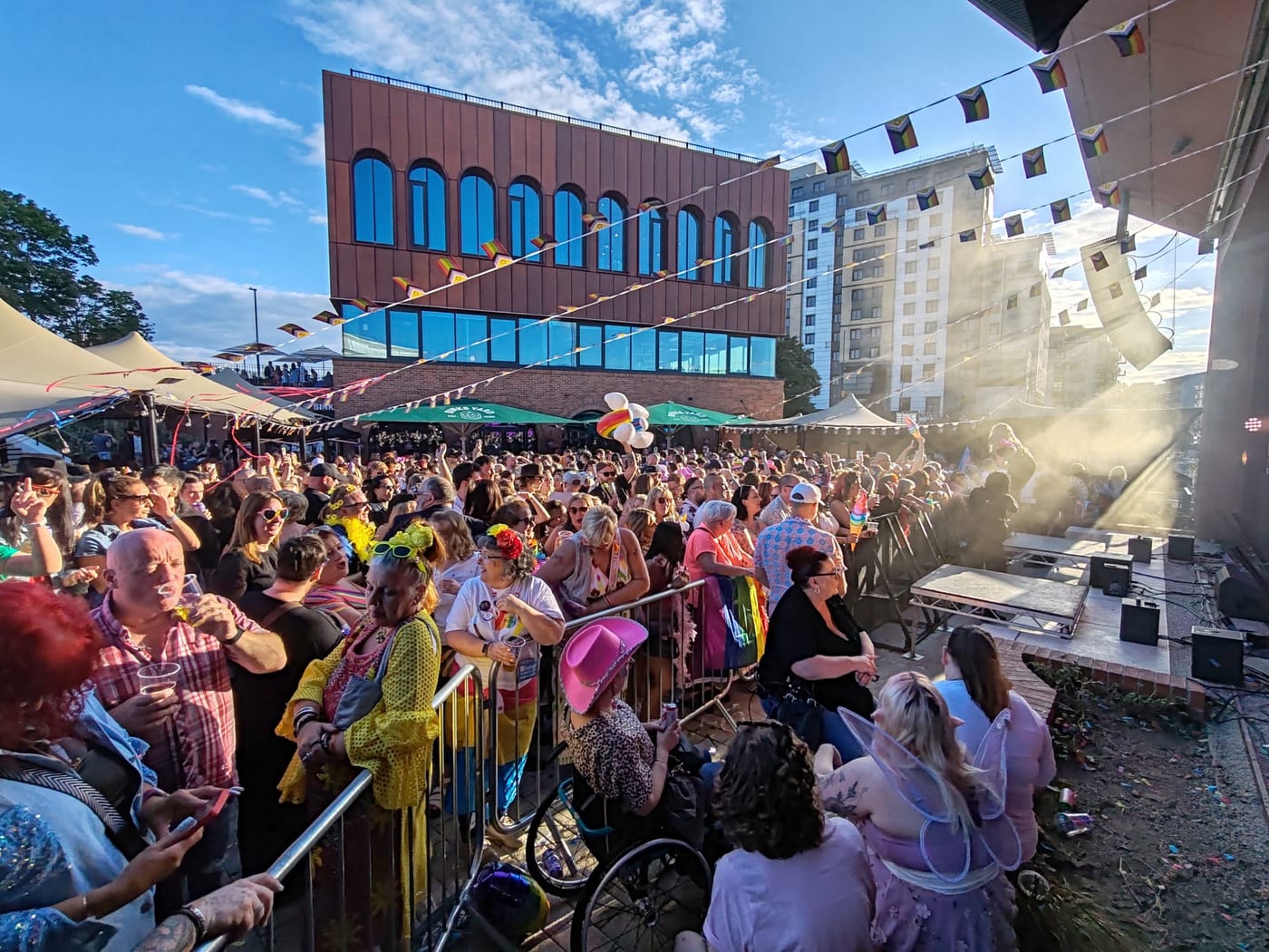 A busy city-centre Pride celebration beneath rainbow flags, where BelvoirCare provided medical cover.
